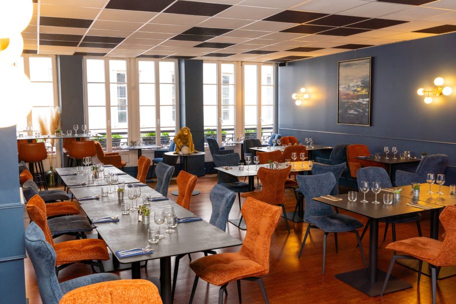 Salle restaurant Besançon L'Y Gargotte Salle de restaurant moderne avec des tables et des chaises colorées. Éclairage chaleureux.