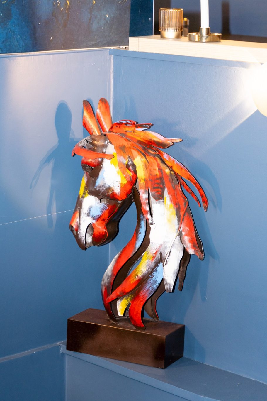 Décoration restaurant Besançon L'Y Gargotte Sculpture colorée d'une tête de cheval, avec des motifs abstraits en rouge et jaune.